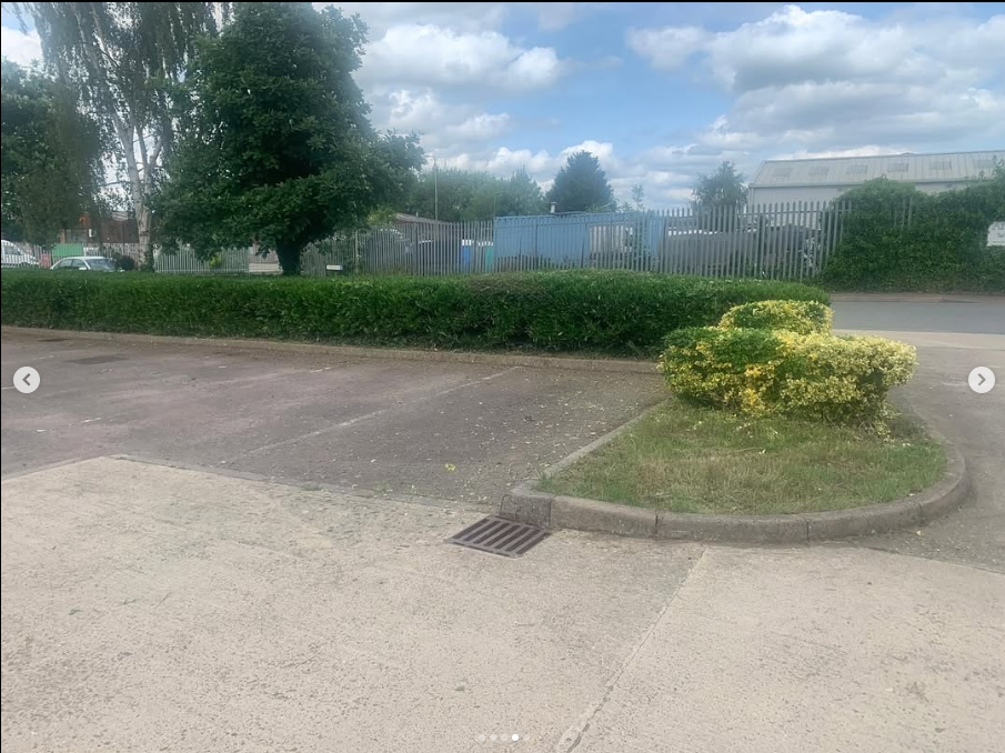 a road with bushes and a fence